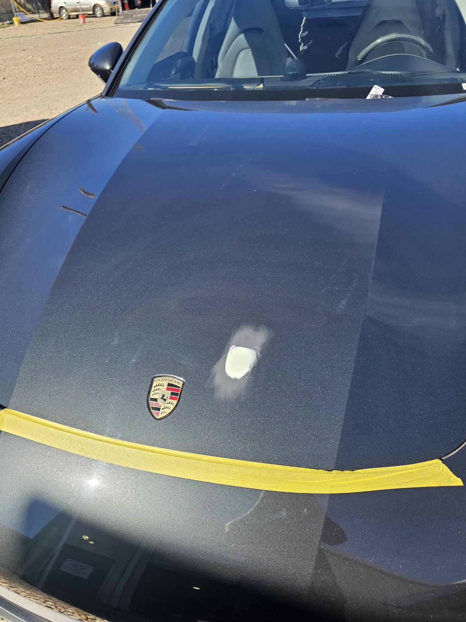 Spot repair work in progress on a Porsche hood